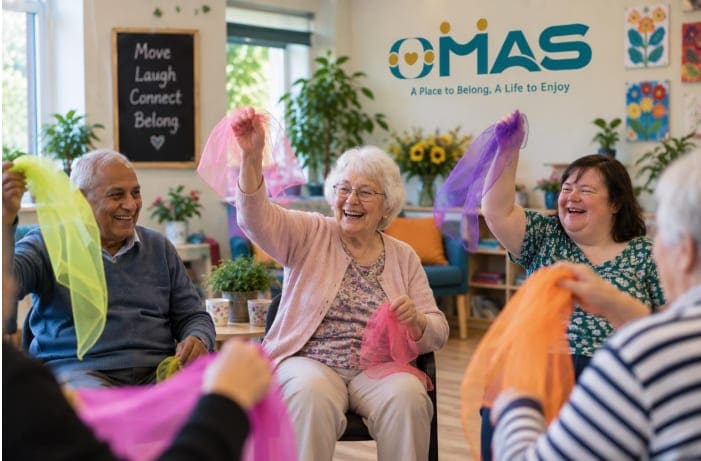 A group laughing and waving colourful scarves during a movement session